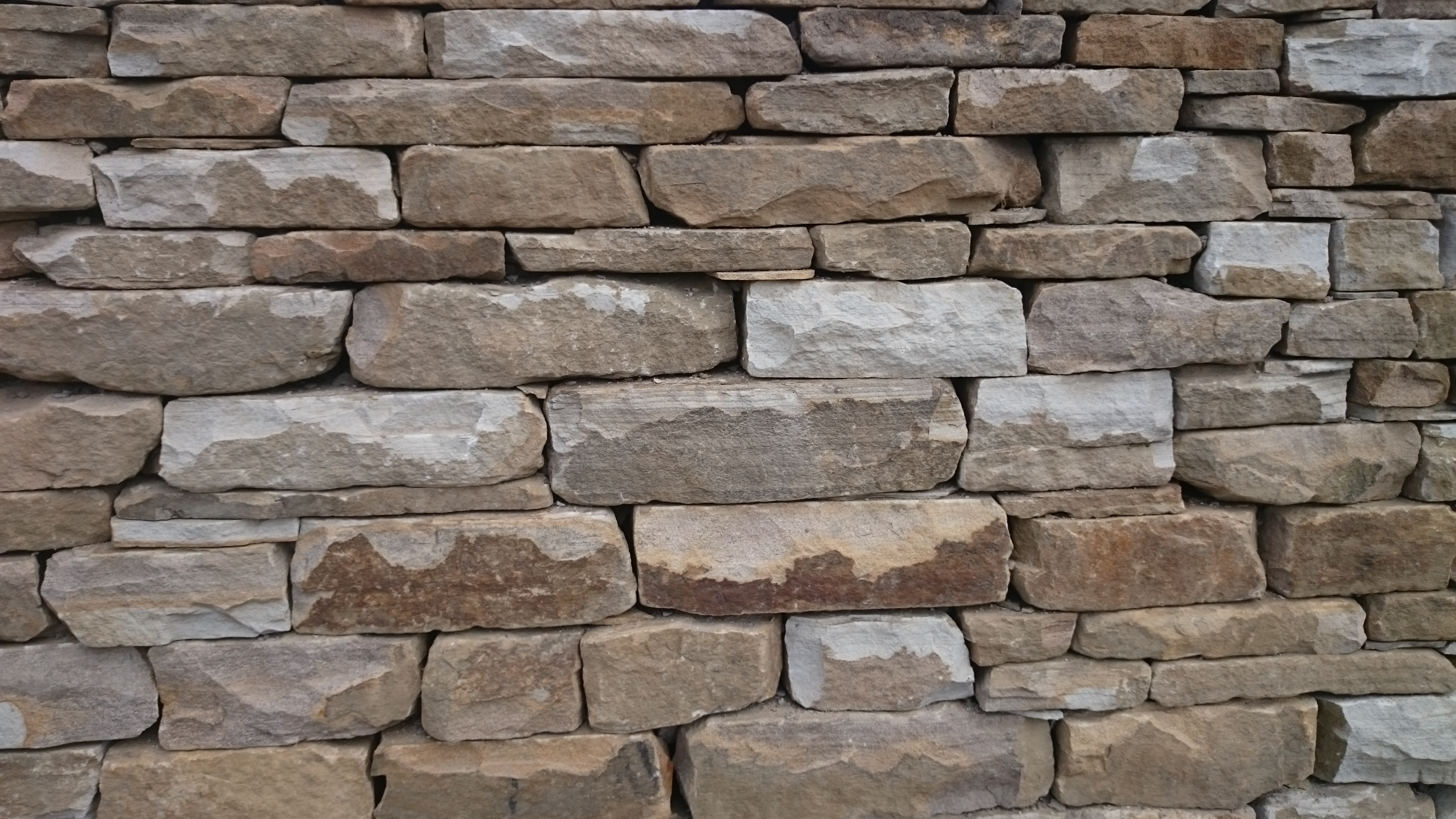 Dry stone effect retaining wall