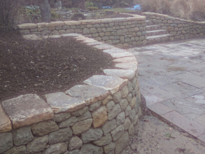 Dry stone retaining wall and flat cap stones