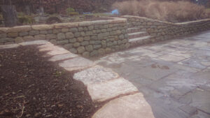 Dry stone retaining wall and flat cap stones