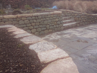 Dry stone retaining wall and flat cap stones